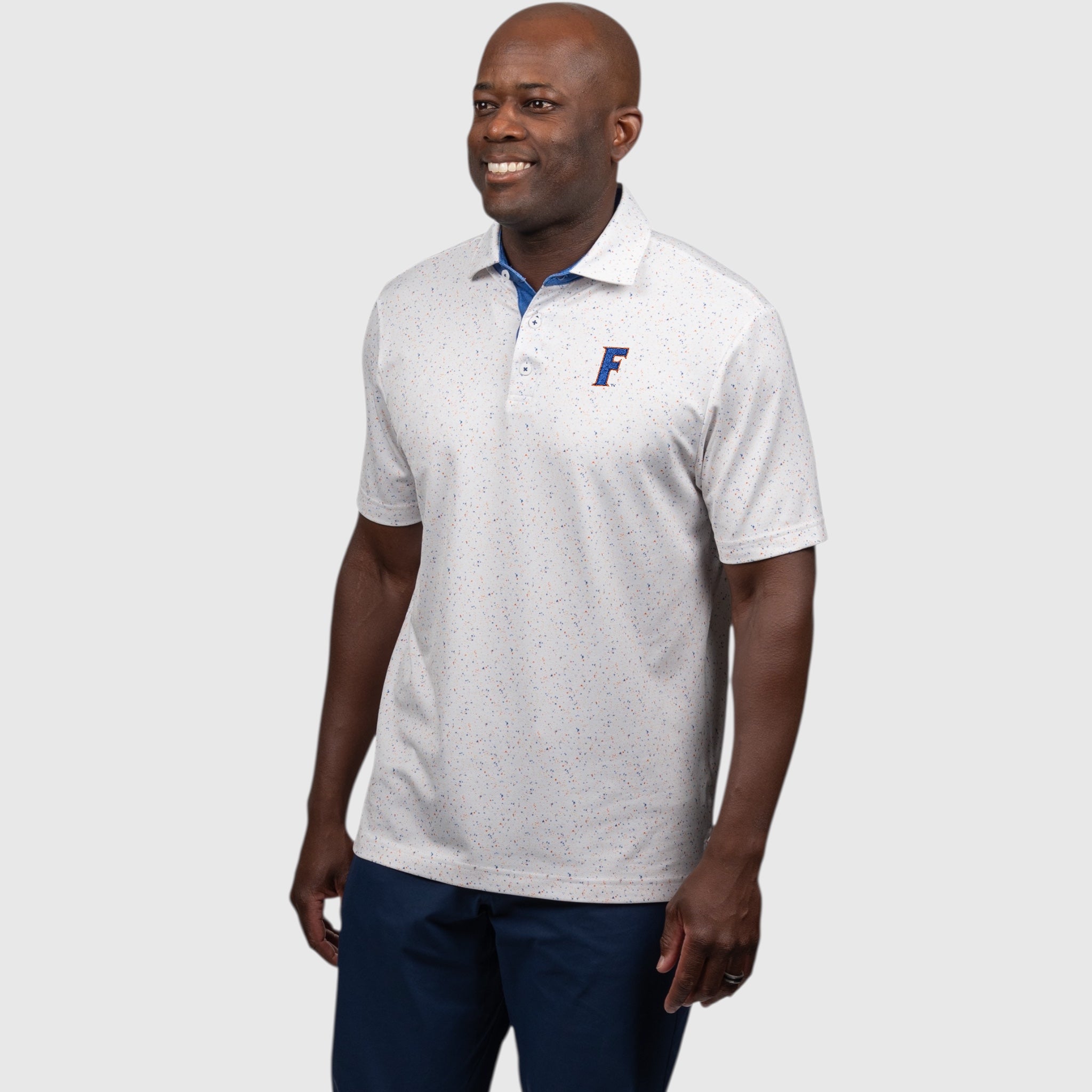 Man wearing a white UF polo shirt with a logo on a light gray background
