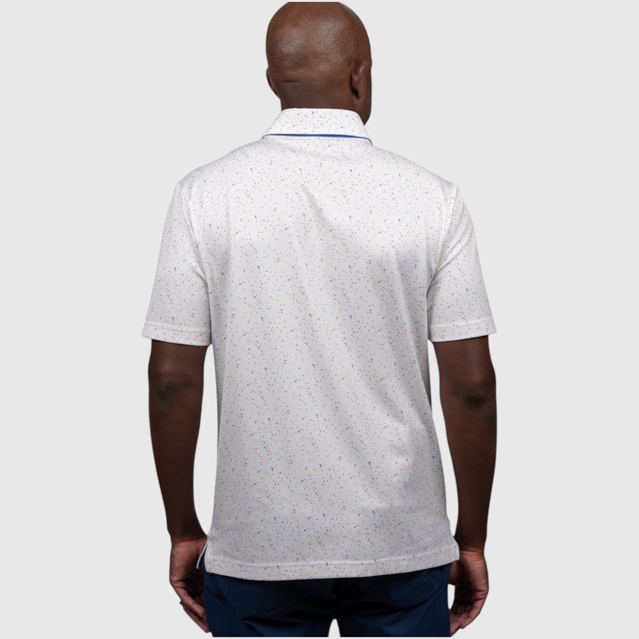 Man wearing a white UF polo shirt with a subtle pattern on a white background